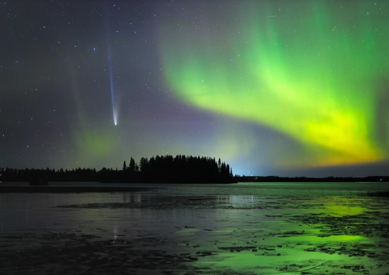 一顆彗星掠過一片綠色的極光